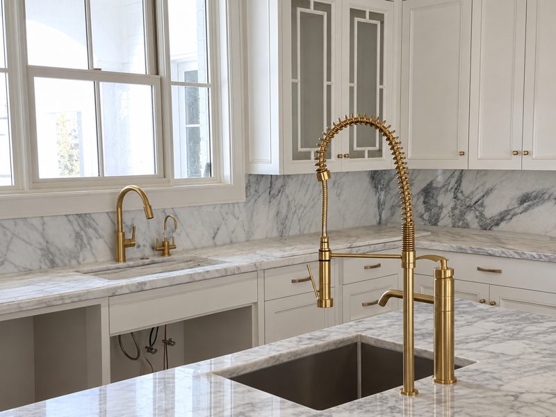 Brass kitchen faucet over an undermount sink