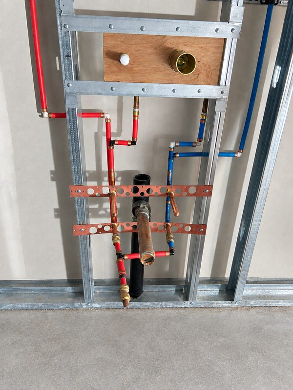 Bathroom sink rough-in with copper stub-outs and PEX in metal studs