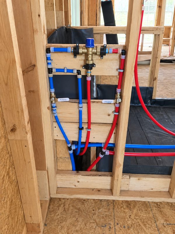 Hot and cold PEX supply lines roughed into a wall